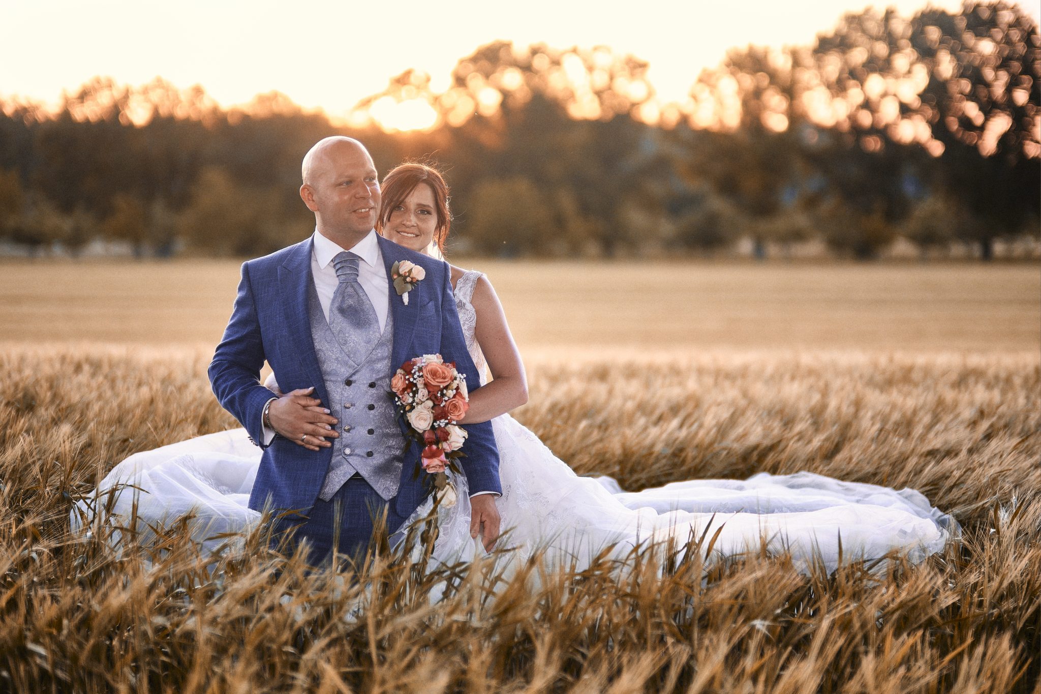 Hochzeitsfotograf Karlsruhe Volker Herzing nimmt Brautppar auf Feld bei Sonnenuntergang auf