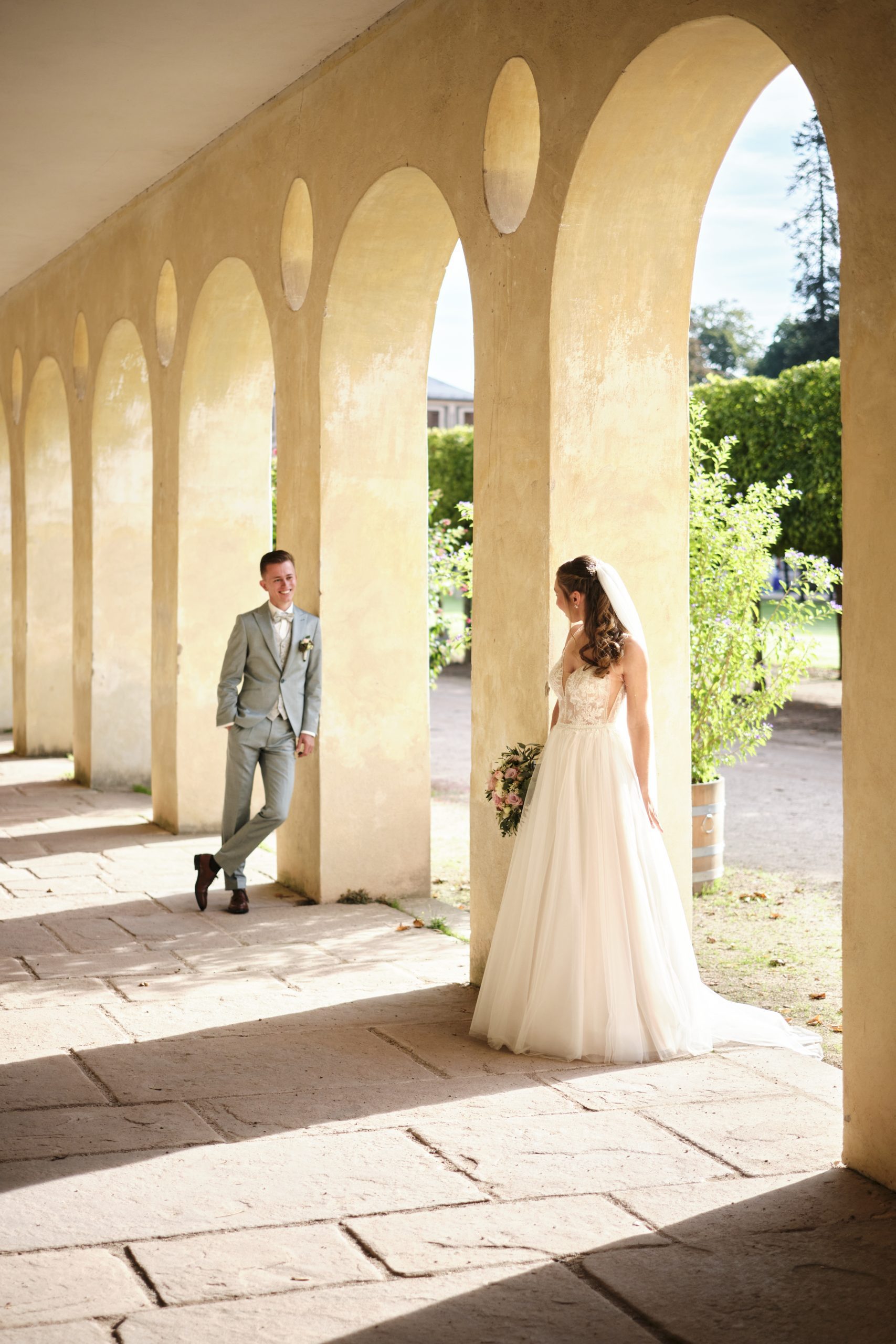 die Orangerie des Schloss Favorit bei Rastatt inspiriert ein Brautpaar zu einem neckischem Versteckspiel hinter den Säulen
