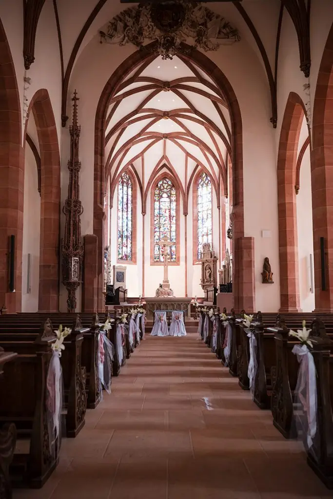 Geschmückter Innenraum der Stiftskirche Baden-Baden für eine romantische Hochzeit.