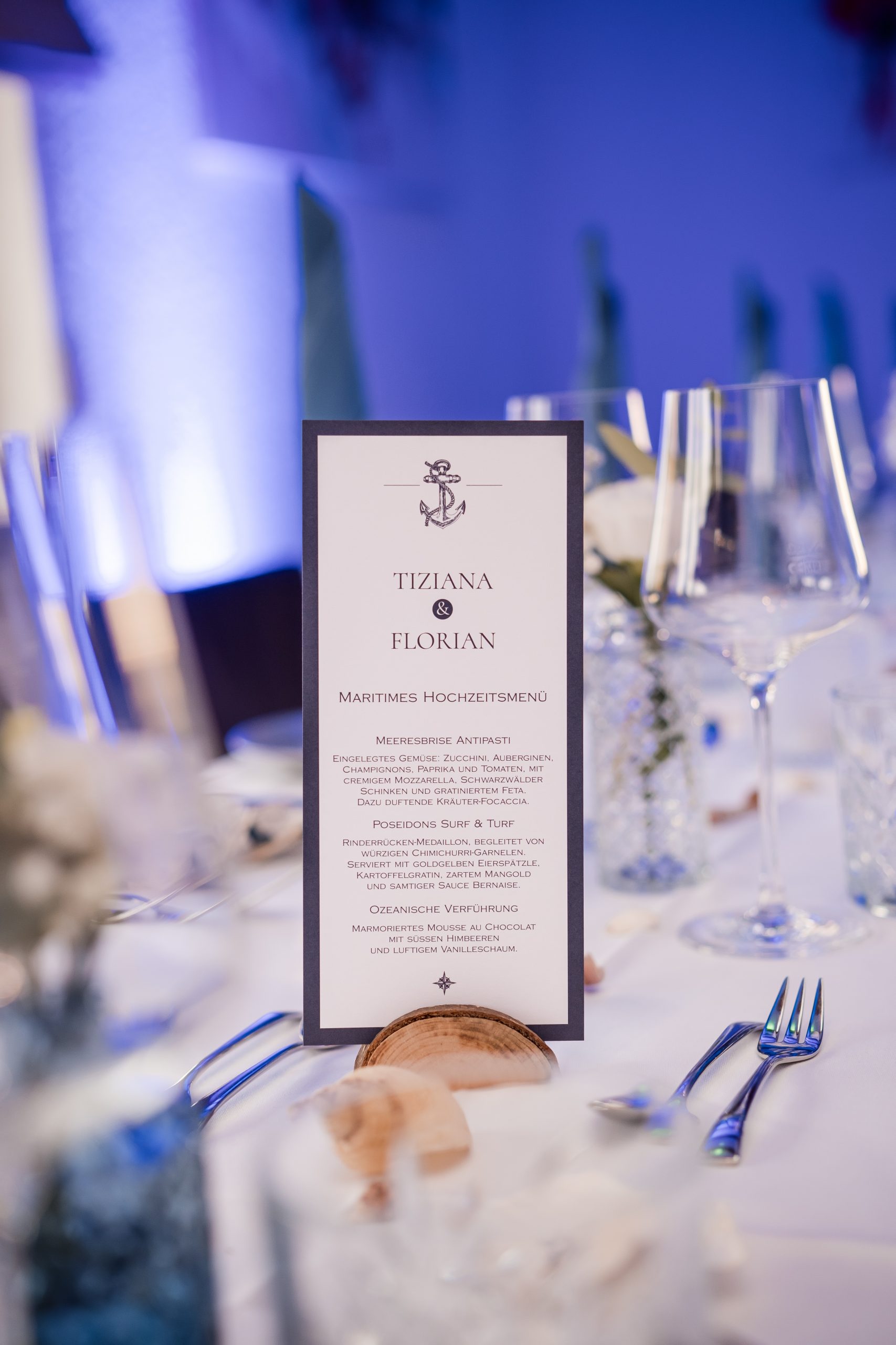 gedeckter Hochzeitstisch in blauer Ambientebeleuchtung