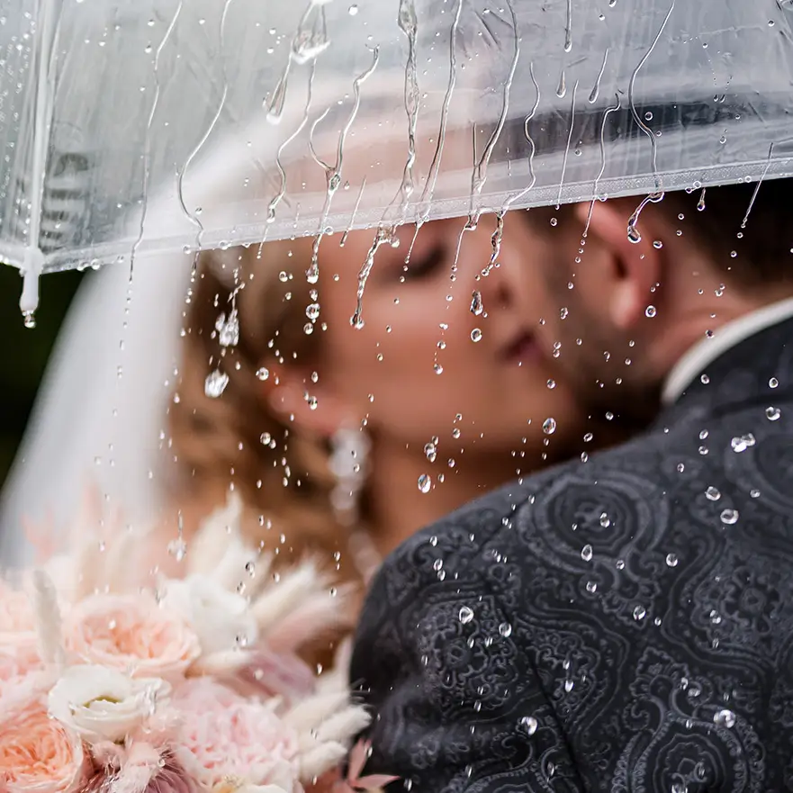 Hochzeitsfotograf Baden-Baden unterwegs in Gernsbach – romantisches Brautpaar küsst sich unter einem Regenschirm bei Regen auf Schloss Eberstein