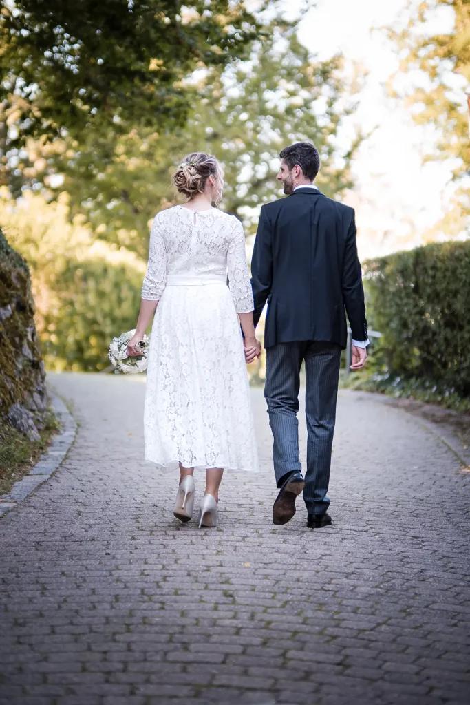 Hand in Hand läuft auf dem Weg zur Burg Windeck ein Brautpaar, dass sich das Wahrzeichen Bühls als Hochzeitslocation ausgewählt hat